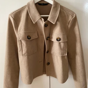 Vårjacka - Jättesnygg beige vårjacka från VERO MODA i storlek XS. Säljes då den tyvärr är för liten. Använd endast ett fåtal gånger så är i nyskick!                         Köparen står för frakten:)