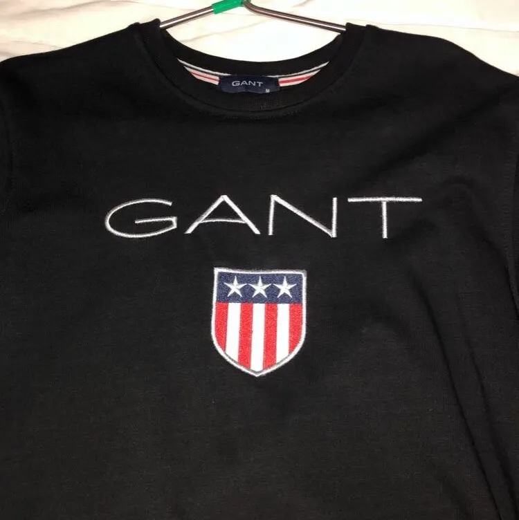 Äkta Gant hoodie utan luva med färgen svart. 50kr om man vill ha påsen med. Priset kan diskuteras (Köper du orginala priset så får du påsen gratis. Lägger till prislappen i de också gratis) Helt ny. Hoodies.