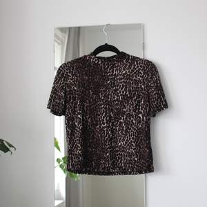 Snygg stretchig T-shirt med halvpolo från Zara i leopardmönster. Storlek S men skulle nog passa en M också.