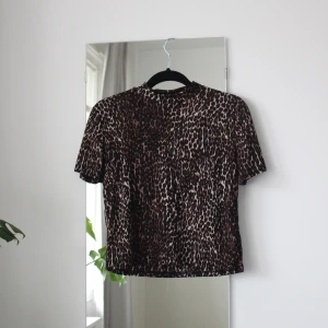 T-shirt från Zara - Snygg stretchig T-shirt med halvpolo från Zara i leopardmönster. Storlek S men skulle nog passa en M också.