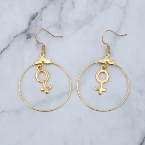 Örhängen med kvinnosymbol  - Fina guldfärgade örhängen med kvinnosymbolen. Nickelfria. 11:- i frakt, fri frakt vid köp över 100:-.