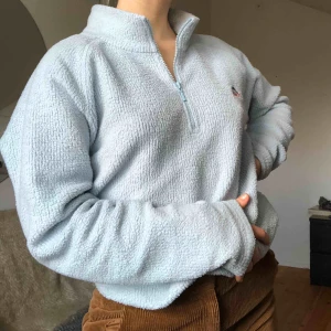  - Ljusblå fleece / teddytröja. Såå snygg och sjukt mysig. Liten fin brodering på bröstet. Zip up vid kragen. Jättefint skick! Storleken är 40, känns som en oversized s:) Möter upp i Lund/Malmö, annars tillkommer frakt!