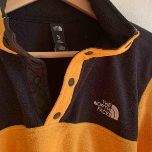 - En north face fleece i färgerna gul & svart. Logga fram på bröstet. Knappar upptill! Knappt använd därav nyskick 🌻