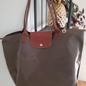 Longchamp le pilage väska  - Säljer longchamp väska modellen heter le pilage den är i färgen mullvad. Fint skick och Äkta 