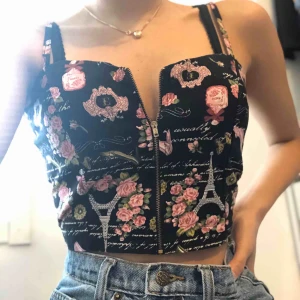  - Svart blommig topp med Eiffeltorn med justerbar dragkedja, endast använd en gång 😊 ( dragkedjan kan vara lite trög ibland ). Säljer pga att den inte kommer till användning, frakt tillkommer på 22kr ✉️