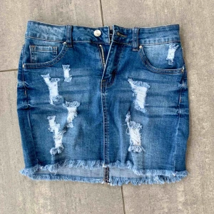  - En jeanskjol med slitningar som aldrig kommit till användning, medelhög midja (navelhöjd) och superstretch! Frakt tillkommer