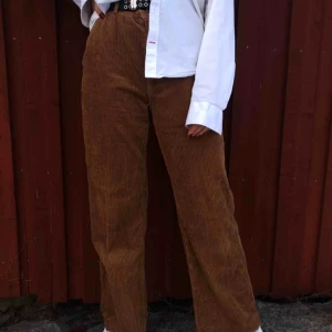  - Ett par bruna byxor i det trendiga materialet manchester. Byxorna är raka i modellen och utsvängda längst ned. Byxorna har framfickor och detaljer där bak. Modellen på bilden är 175 cm🥰 