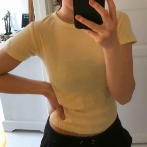 Gul t-Shirt - Basic ljus-gul t-shirt köpt på Urban outfitters i storlek s - med vitt broderi på ena armen. Kontakta mig för fler bilder! :) 