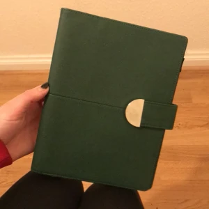 bok/kalender skydd - du sätter in en egen kalender eller bok. det funkar som ett skydd plus att den har små fickor för post-itlappar exempelvis + en liten hållare för en penna. grön skinn-imitation. skriv gärna vid frågor ❤️