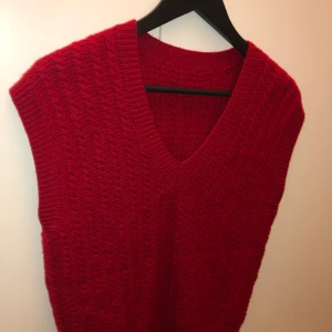 Stickad väst - Säljer denna röda stickade väst då den inte kommer till användning för mig😇 sitter som en storlek S skulle jag säga👍🏼 frakt tillkommer 