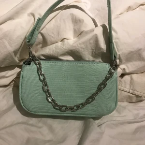 Trendig Axel väska - Trendig baugette bag/Axel väska. Fin turkos färg med en silvrig kedja. Kommer tyvär inte till användning💗💗