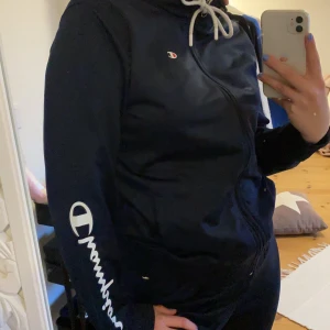 Champion Reverse hoddie - En jätte fin champion hoddie med luva och dragthedja använd 1-2 gånger då de ej är riktigt min stil✨ Färgen är mörk marinblå och vita tryck. Storleken är L. Frakten står man för själv