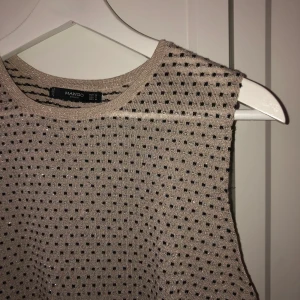 Stickad väst  - Beige stickad väst med svarta prickar, lite glittrig i tyget. Köpt på mango och använd ett fåtal gånger. Storlek m 
