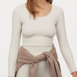 Träningströja - Beige croppad träningströja från HM. Köpt i somras och endast använd en gång. Superfin och går att använda som vanlig tröja också. Den är ribbad. Skänt material och sitter fint på.