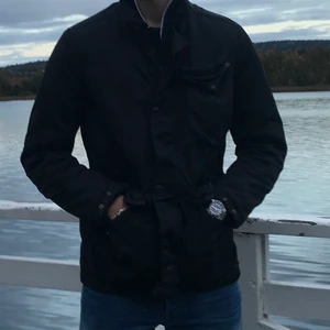 CP Company jacka XXL - Höstjacka från C.P Company. Storlek XXL. Avtagbar luva med goggles. Köpt på Terrace. Nypris 12 000kr. Mycket bra skick förutom att ena knappen på fickan har trillat av. Använd ca 3 månader förra vintern/våren