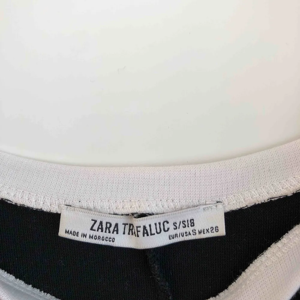 Svart knälång klänning med skulpterande vita detaljer från Zara. Storlek S.. Klänningar.
