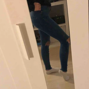  - Mörkblå tighta jeans med hål på knäna från ginatricot i modellen Molly. Jeansen är fortfarande i bra skick men de kommer tyvärr inte till användning längre.
