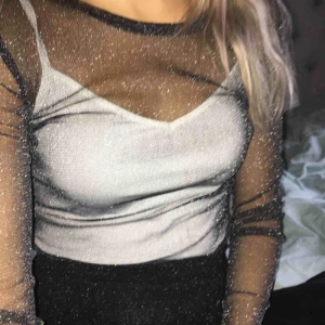  - Transparent glittertopp med lång ärm. Från Gina Tricot 