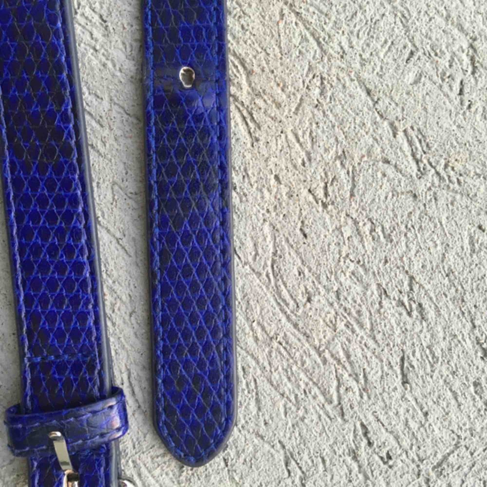 Skärp i najs blå färg samt med kedja. Max nått i midja 70 cm (mätt från yttersta skärphålet), så ganska litet skärp. Frakt tillkommer, kan annars mötas upp☺️👾 observera att sista hålet är lite slitet, men går absolut att använda ändå.. Accessoarer.