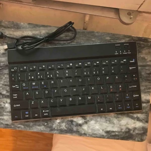 Bluetooth tangentbord, laddningsstatus medföljer - Ett väldigt sparsamt använt mini tangentbord som man kopplar till iPad osv genom bluetooth. Från Linocell. Köpt på Kjell & Co för 349kr. En micro USB kabel medföljer. Bra batteritid!  