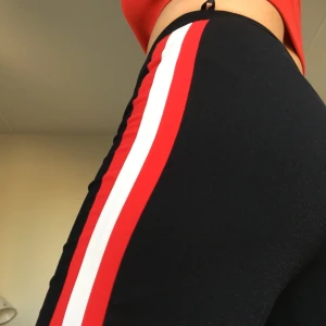  - Svarta kostym byxor med röd-vita stäck på ytterkanterna! 