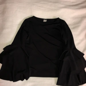  - Fin svart tröja med volanger på armarna. Så gott som oanvänd!