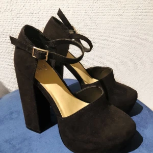  - Svarta klackar från Nelly.com i mockaliknande material.  Oanvända men provade inomhus, säljes pga. att de inte kommit till användning något.   Klackhöjd: 13cm Platåhöjd: 4cm   Vid frakt står köparen för kostnaden!