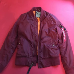  - Vinröd Alpha Industries bomberjacka (dam). Säljs p.g.a den är för stor.