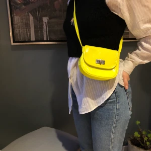 Neongul crossbodybag - Liten väska som jag köpt secondhand. Perfekt till fest! Defekt på spännet (färg), se bild.