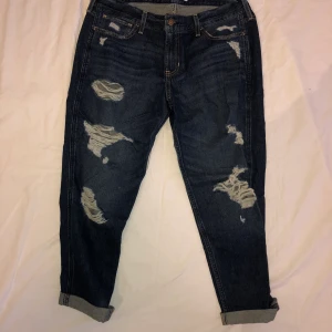 Slitna jeans från Hollister - Mörkblåa boyfriend jeans med slitningar från hollister. Står att storleken är W30, men de är rätt korta i modellen. Köparen står för frakten :)