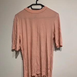 Gina Tricot pink shirt with ribbed material  - Size large, very stretchy and soft material with mid length sleeves and high collar. Bought second hand but never worn. 