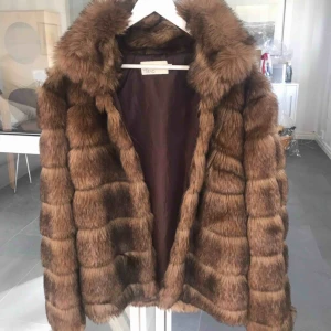  - En brun fakepäls från Nelly.com i storlek 38. Stor krage och fungerar jättebra som vinterjacka.  Köpt för 1000 kr. 