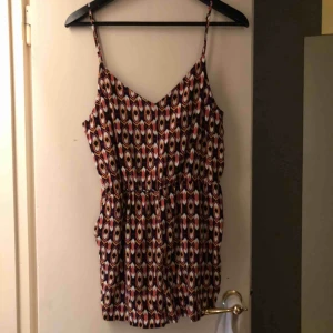  - Jumpsuit med ett härligt mönster, aldrig använd. Fint trådmönster i ryggen. Fickor finns och köparen står för frakten.