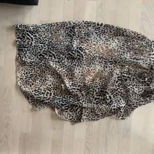Lång kjol från Miss Selfridge i leopardmönstrad. Den har en underkjol (så den inte är genomskinlig), lagerna över ligger omlott och den är skuren/kortare på vänstersidan. Dragkedja på sidan, väldigt fint häng. Använd ett fåtal gånger så är i nyskick :) återkom om ni vill ha fler detaljer 🤗