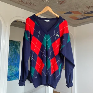 Rutig tröja - Superfin rutig Lacoste-tröja i väldigt bra skick, köpt second hand. Sitter fint oversized på mig som passar i XS/S och är 160 cm lång, så passar nog allt mellan S-L. Köparen står för frakt!