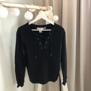 Svart tröja med snörning - En svart tröja från HM med snörning framtill. Storlek xs men passar även s. Frakten ingår i priset!!
