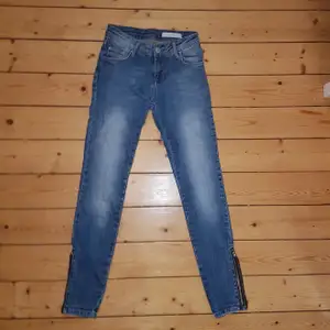 Ett par blå jeans med snygg tvätt och dragkedja på båda byxbenen vid ankeln. Slimfit💙
