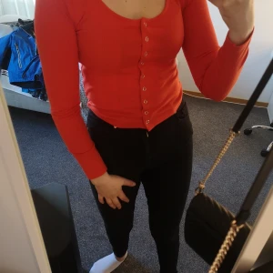 Orange/röd topp - Strl S. Jag är 170.5 cm. Knapparna känner man inte av och de går och dra bort så tröjan är öppen sma till 0703373834. 