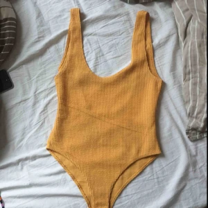 Gul body - Jättefin, gul body från BikBok! Helt oanvänd, men hopsydd nertill.