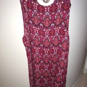 Ny söt blommig klänning - Aldrig använd, mjuk i tyget, knälång (något kortare).. storlek liten L , säljer billigt, hämtas eller skickas