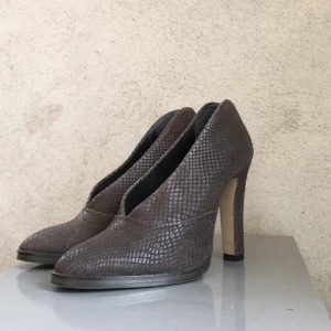  - Mörkgrå ormmönstrade klackar från FilippaK. Liten 37a. Använd 1 timme. Säljes pågrund av för små. Ordinarie pris: 2500kr