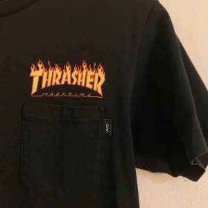 Thrasher x Vans T-shirt med as fett tryck back & en liten ficka fram, kommer inte till användning, den är som ny. Sitter mer som en M