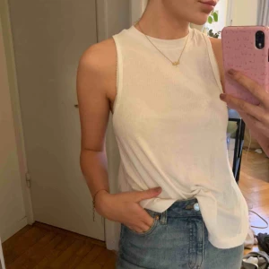  - Vit topp i ribbat material. Priset är exklusive frakt. 