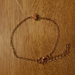 Armband m. Litet hjärta  - Armband i guld-bronsig ton med ett litet hjärta. Kedjan passar mellan 18 och 23 cm runt handleden. Säljer för 19kr exklusive frakt (11kr).Dock ingår alltid gratis frakt vid köp över 300kr. Skriv i dm vid intresse eller för frågor! 🥰