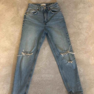  - Trendiga jeans från zara med hål på knäna. Supersköna och bra kroppspassform. Fin ljusblå färg! Perfekt till en vit överdel. Köpte för 499kr och säljer för 250kr. 💕