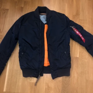 Jacka - Mörkblå Bomber jacka med orange. Mycket bra skick!! Tjocka modellen. Köpt för 1350kr