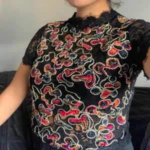 Topp från ZARA - Söt topp i svartspets med brodyr och kedja i ryggen 