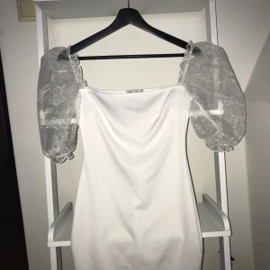 Vit sommar-klänning, Nelly, puffärm/ballongärm - Oanvänd, jätte fin, vit klänning från Nelly med puffärm/ ballong-ärm som är ett genomskinligt skimrigt tyg, den är i storlek XS