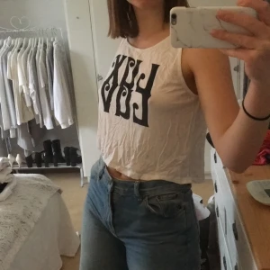 Topp  - En vit topp med svart tryck. Den är väldigt luftig och är gjort av ett tunt material!