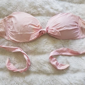 Rosa bikini top - Rosa bikiniöverdel. Har några år på nacken så resoren i knytbanden har torkat inuti. Vita bitar kan synas när den är blöt se bild 2,(obs dåligt ljus), detta kan man åtgärda om man vill göra ett litet hål i bak. :) lite blek i färgen. Frakt ingår!